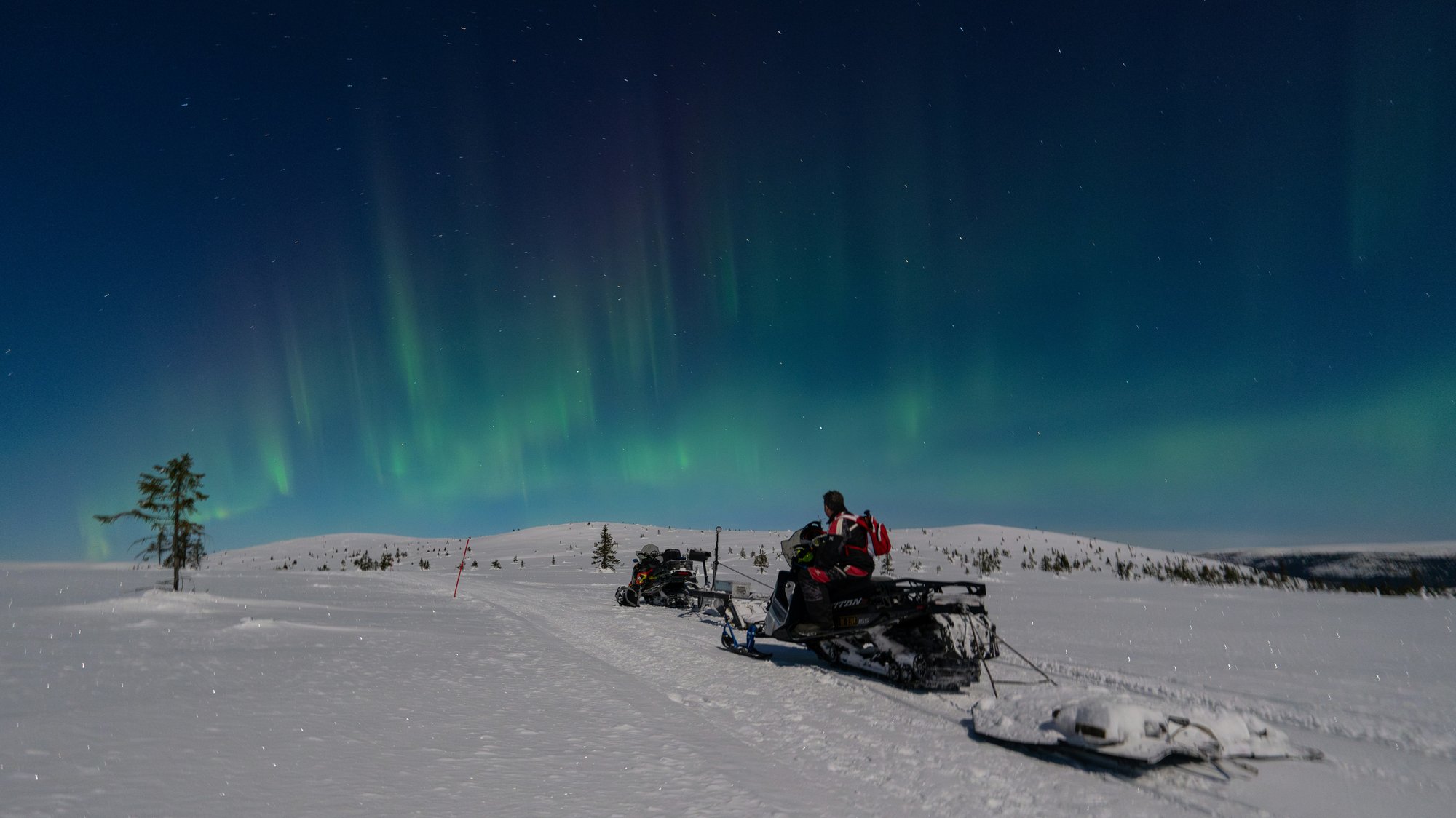 mann-på-snescooter-nordlys-Norge